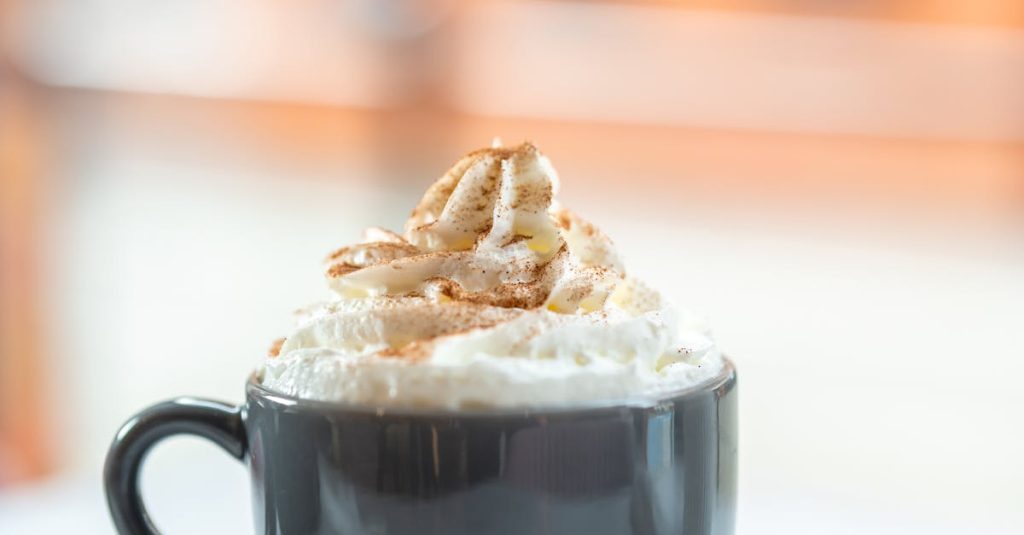 Warm cappuccino with whipped cream in a New York café setting.